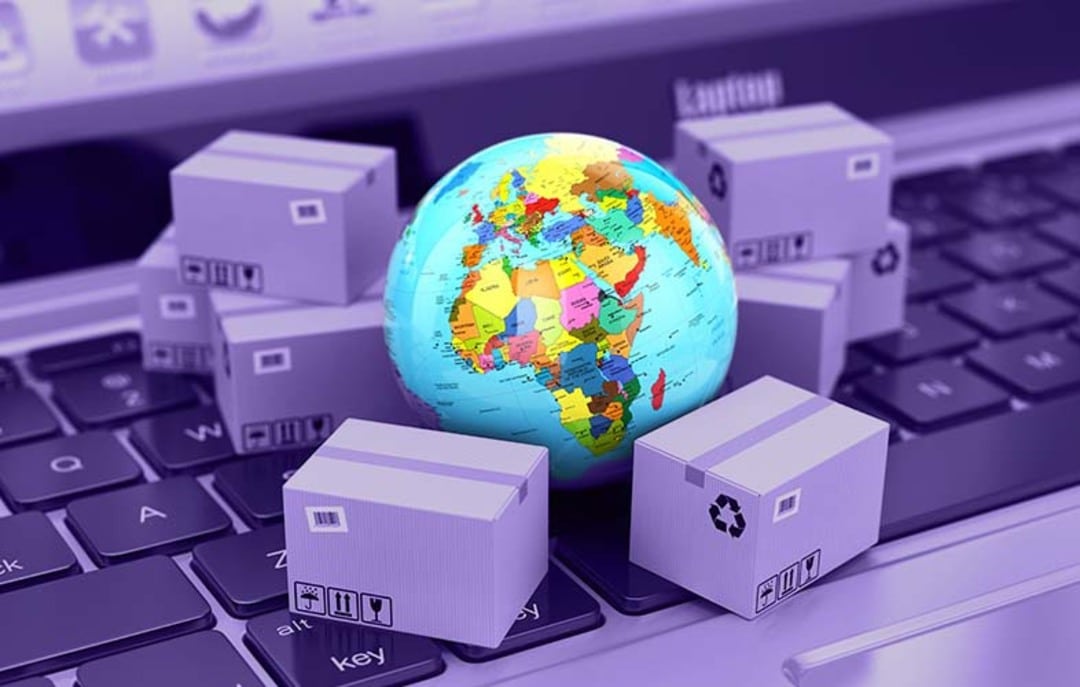 Imagem com filtro roxo, com caixas de papelão e globo terrestre colorido, ambos em miniatura, representando a gestão de distribuição.
