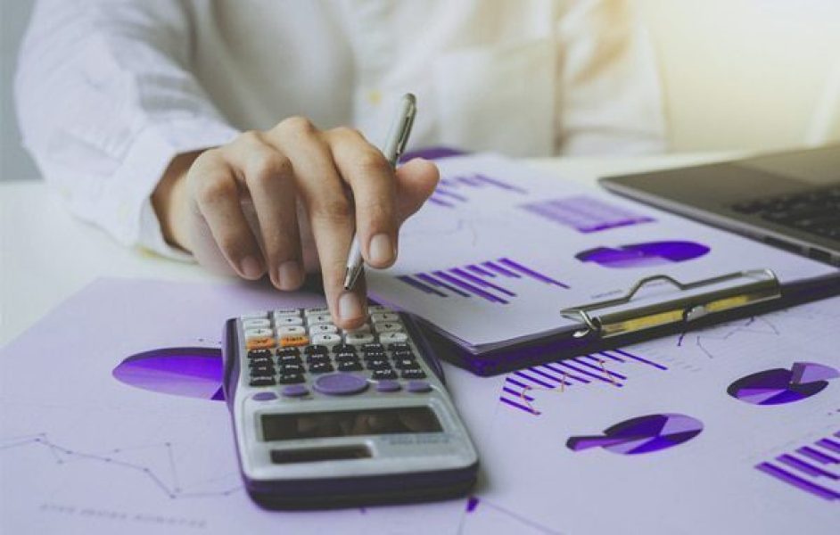 pessoa-utilizando-uma-calculadora-com-alguns-graficos-sob-a-mesa